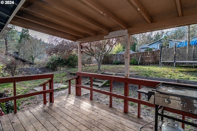 wooden deck with a trampoline and grilling area