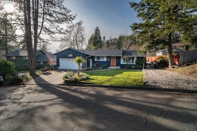 ranch-style home featuring a front lawn and a garage