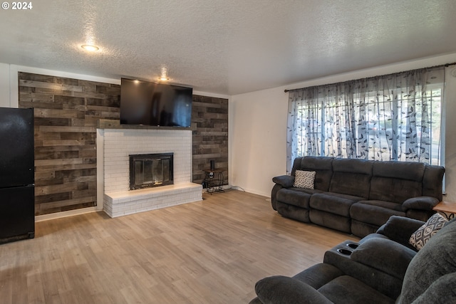 living room featuring a fireplace, a healthy amount of sunlight, hardwood / wood-style flooring, and wooden walls