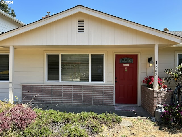 view of exterior entry with covered porch