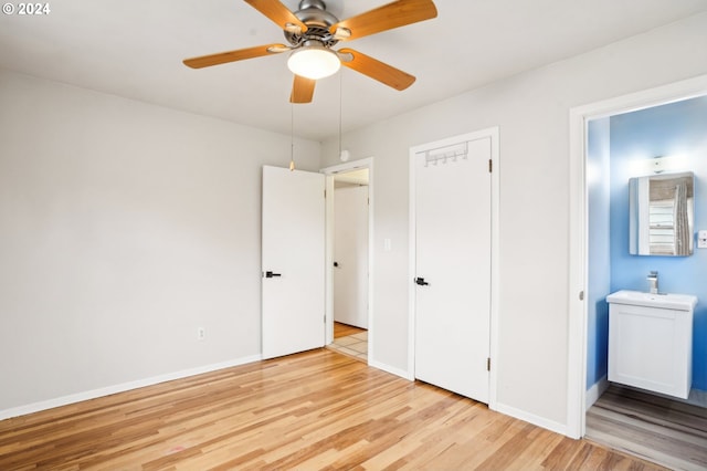 unfurnished bedroom with sink, ensuite bathroom, ceiling fan, a closet, and light wood-type flooring