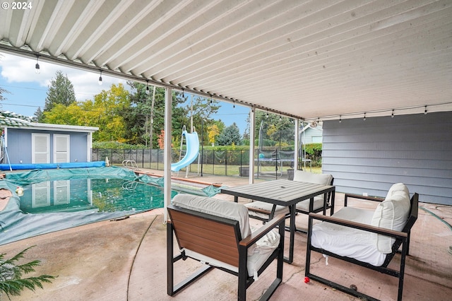 view of patio with a shed and a covered pool