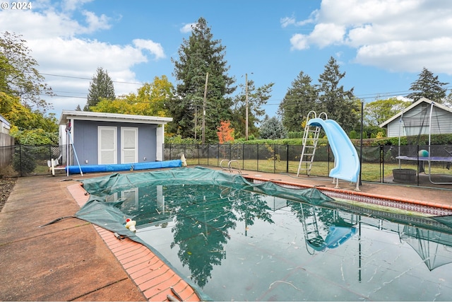 view of swimming pool featuring an outdoor structure and a water slide