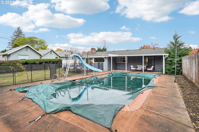 view of swimming pool with a water slide and a patio area