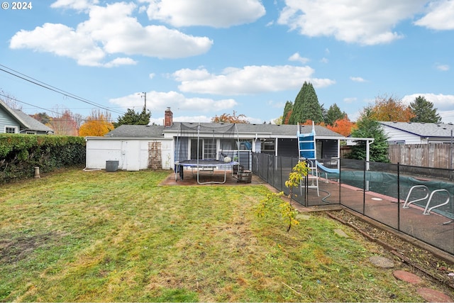 rear view of property with a fenced in pool, a patio area, cooling unit, and a yard