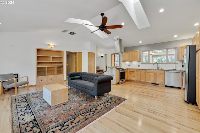 living area with visible vents, recessed lighting, ceiling fan, light wood-style floors, and lofted ceiling with skylight