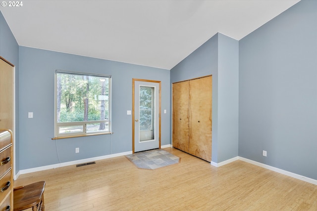 entrance foyer featuring lofted ceiling, wood finished floors, visible vents, and baseboards