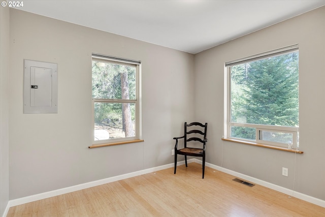 sitting room featuring electric panel, visible vents, a wealth of natural light, and wood finished floors