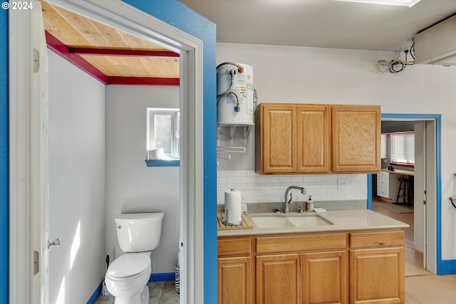 bathroom with vanity, baseboards, water heater, decorative backsplash, and toilet