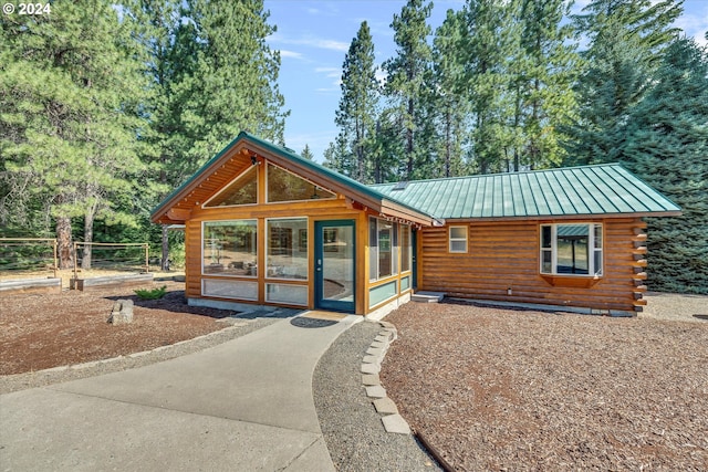 log cabin featuring metal roof, a standing seam roof, and a sunroom
