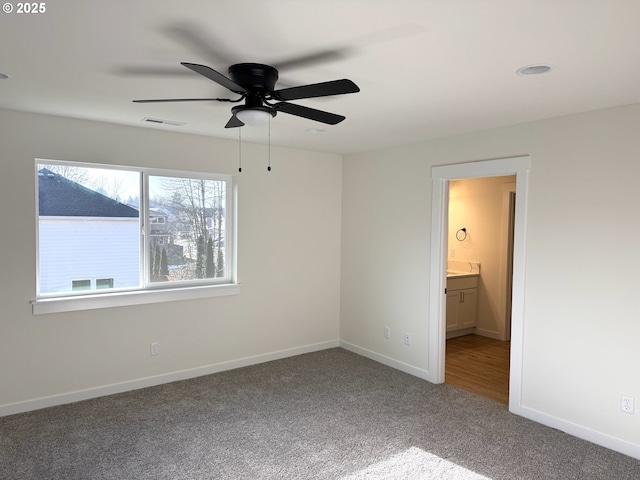 unfurnished bedroom with carpet, ensuite bathroom, and ceiling fan