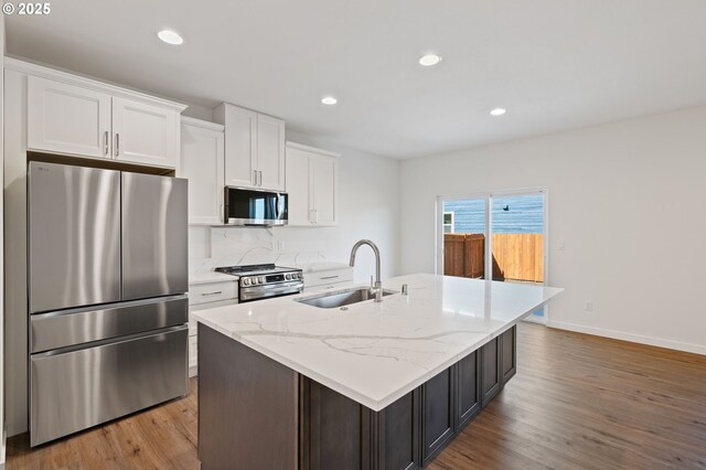 11122 NE 91st Ave, Vancouver, WA 98662 - kitchen featuring wood finished floors, a center island with sink, white cabinets, a sink, and stainless steel appliances