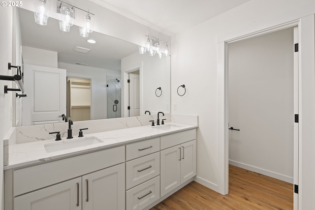 11122 NE 91st Ave, Vancouver, WA 98662 - bathroom featuring double vanity, baseboards, a sink, and wood finished floors