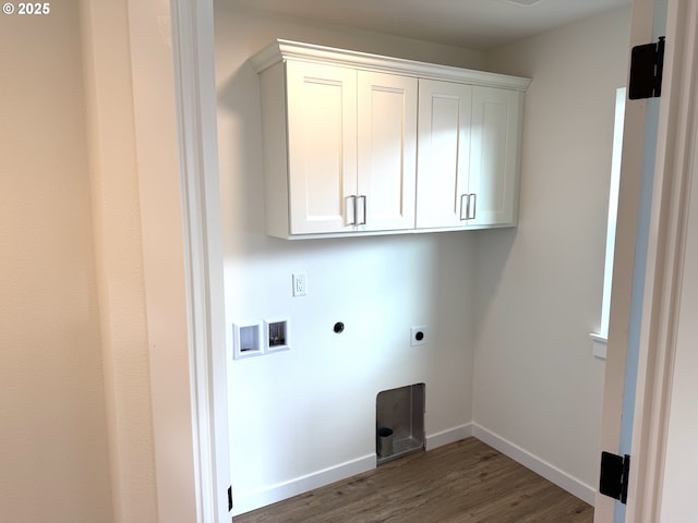 laundry room with electric dryer hookup, hookup for a washing machine, hardwood / wood-style floors, and cabinets