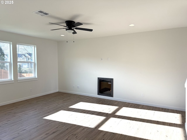 unfurnished living room featuring dark hardwood / wood-style floors and ceiling fan