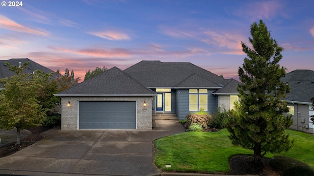 view of front of property with a yard and a garage