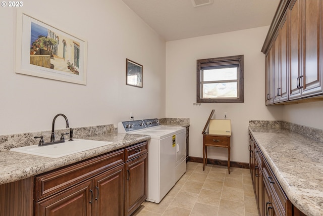 laundry room with cabinets, sink, light tile patterned floors, and washing machine and clothes dryer