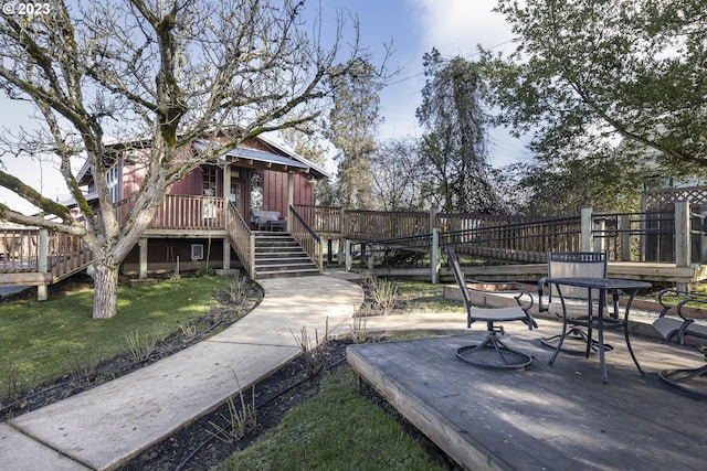 view of home's community with a deck and a yard