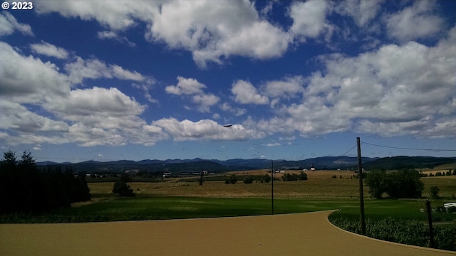 view of community featuring a mountain view, a yard, and a rural view