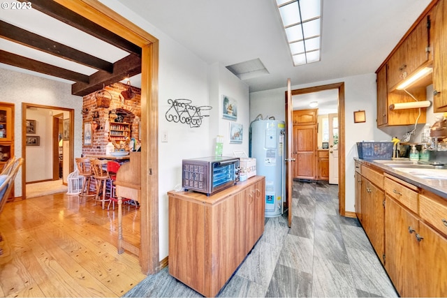 kitchen featuring light hardwood / wood-style floors, electric water heater, sink, and beam ceiling