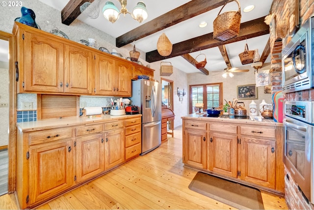 kitchen featuring beamed ceiling, light wood-type flooring, tasteful backsplash, ceiling fan with notable chandelier, and appliances with stainless steel finishes