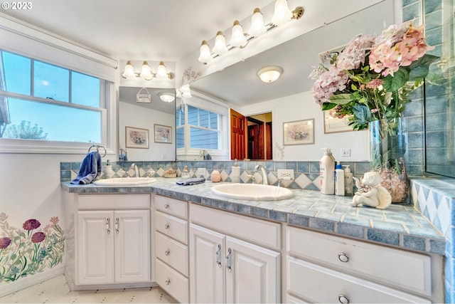 bathroom with a healthy amount of sunlight, vanity, and tasteful backsplash