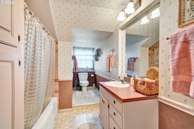 full bathroom featuring toilet, shower / bathtub combination with curtain, and vanity