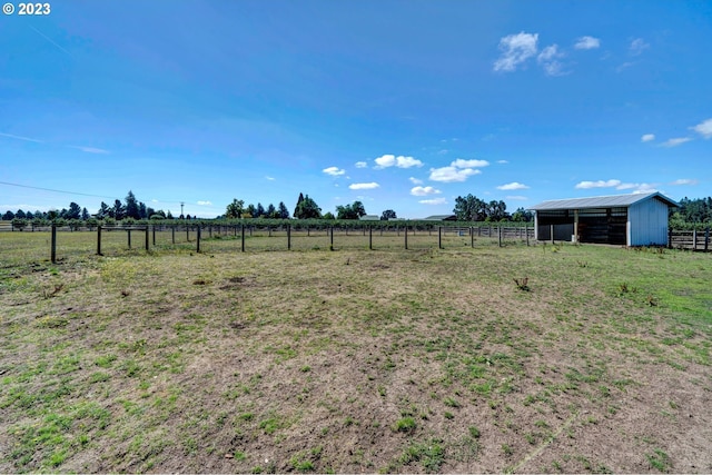 view of yard with a rural view and an outbuilding