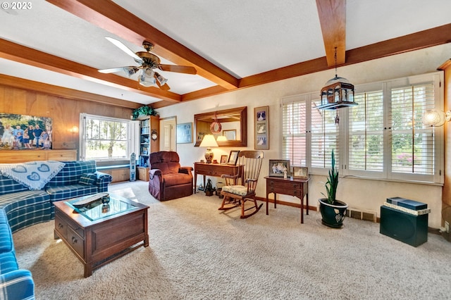 carpeted living room featuring ceiling fan and beamed ceiling