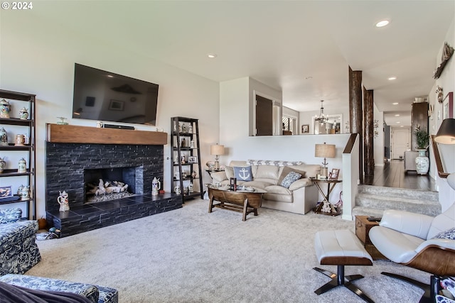 carpeted living room featuring an inviting chandelier and a fireplace