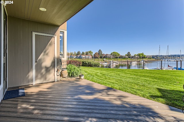 deck with a lawn and a water view