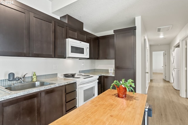 kitchen with light wood-type flooring, white appliances, dark brown cabinetry, sink, and washer / dryer