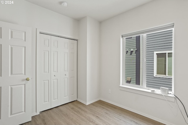 unfurnished bedroom with a closet and light hardwood / wood-style flooring