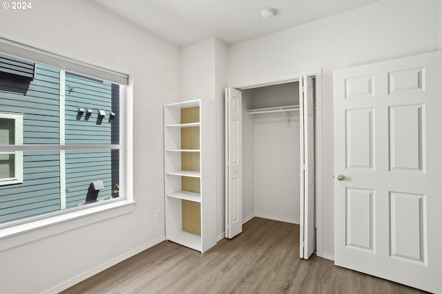 unfurnished bedroom featuring a closet and light hardwood / wood-style floors