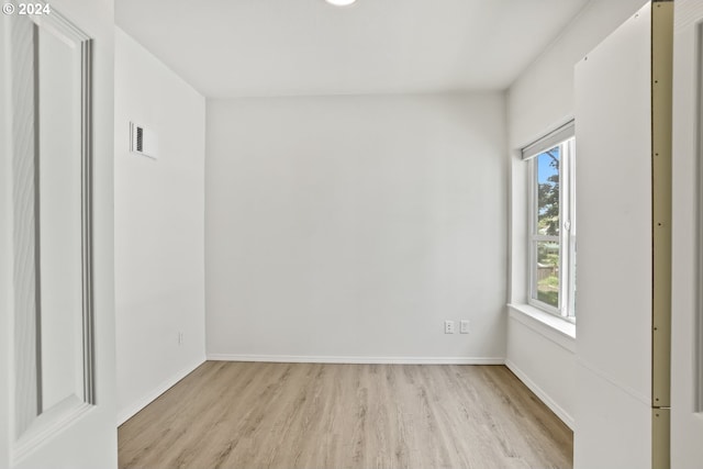 unfurnished room with a healthy amount of sunlight and light hardwood / wood-style floors