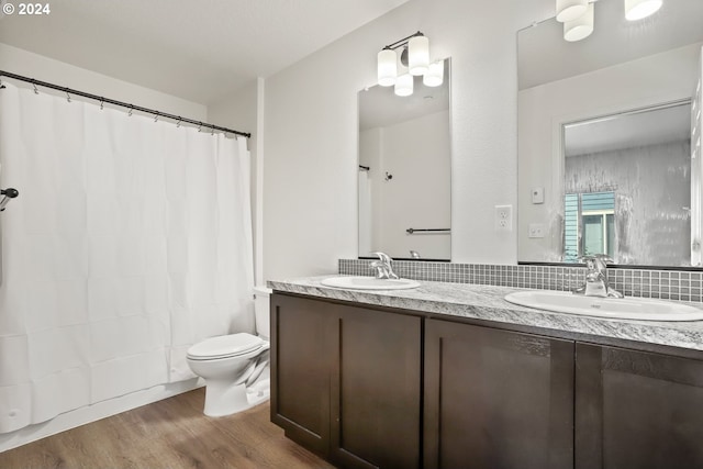 full bathroom with backsplash, wood-type flooring, toilet, shower / bath combo with shower curtain, and vanity