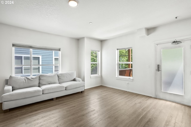 unfurnished living room featuring hardwood / wood-style floors and a textured ceiling