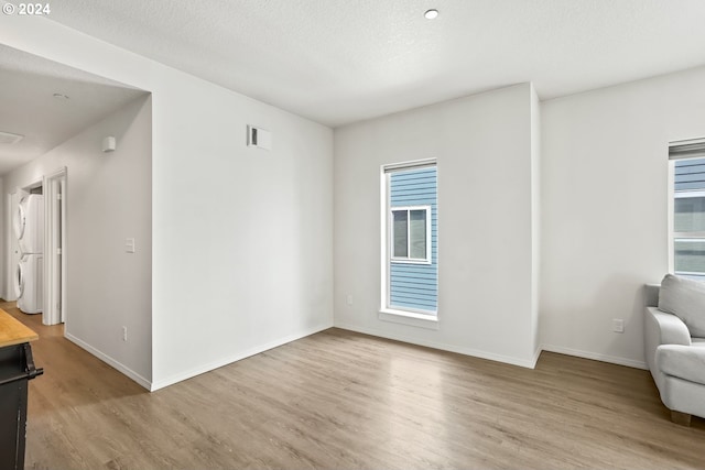 interior space with washer / dryer, a textured ceiling, and light hardwood / wood-style flooring