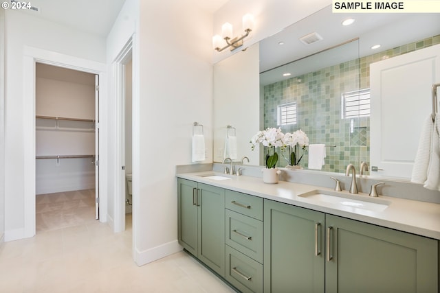 bathroom with tile patterned flooring, a tile shower, vanity, and toilet