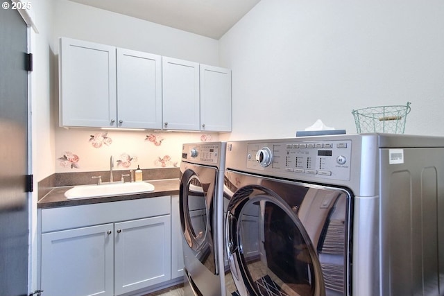 washroom featuring cabinets, sink, and washing machine and clothes dryer