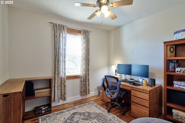 office area featuring ceiling fan, light hardwood / wood-style floors, a textured ceiling, and plenty of natural light