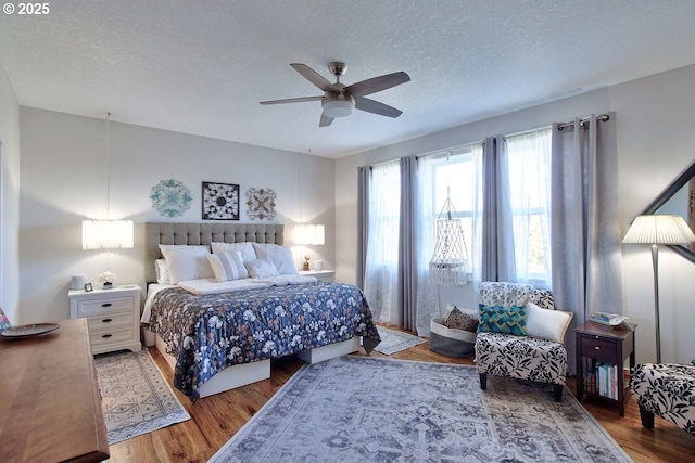 bedroom with ceiling fan, a textured ceiling, and wood-type flooring