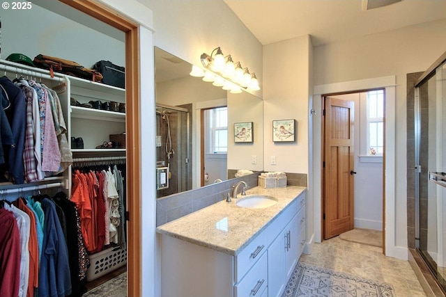 bathroom with plenty of natural light, walk in shower, and vanity