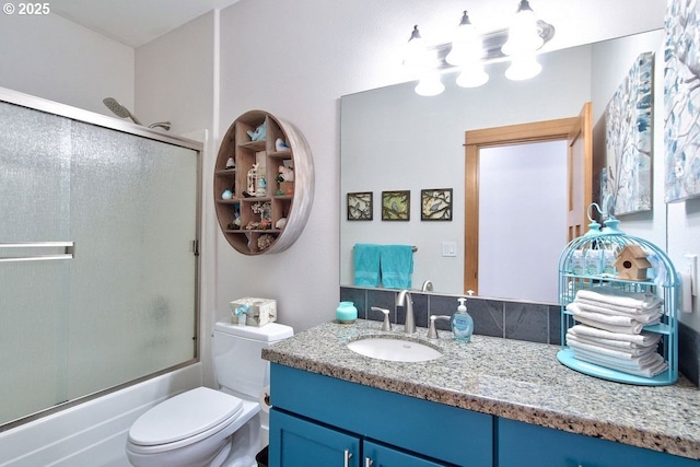 full bathroom with vanity, toilet, and combined bath / shower with glass door