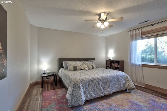 bedroom featuring hardwood / wood-style flooring, a textured ceiling, and ceiling fan