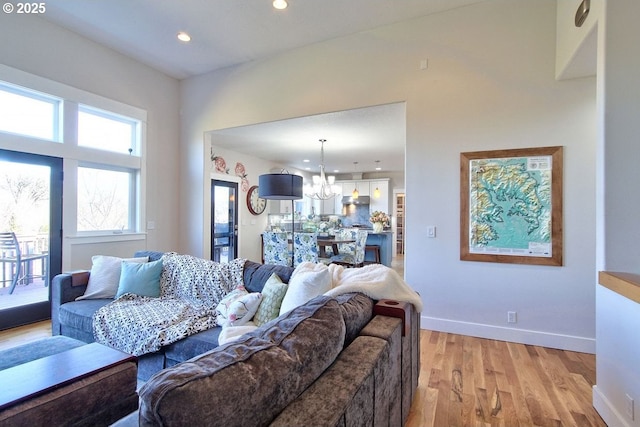 living room with light hardwood / wood-style flooring and an inviting chandelier