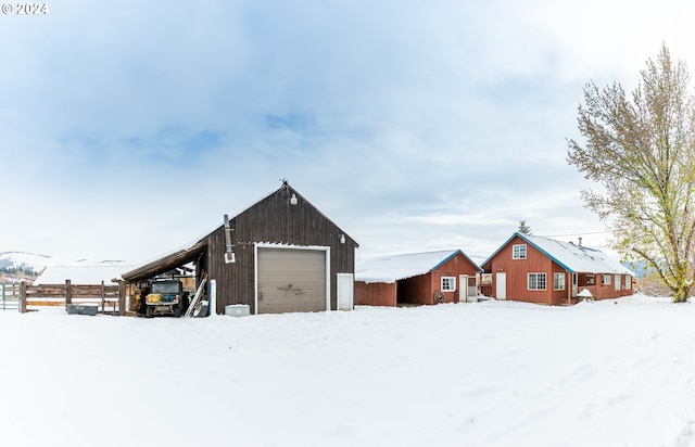 snow covered structure featuring a garage