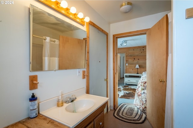 bathroom featuring vanity, walk in shower, and wood walls