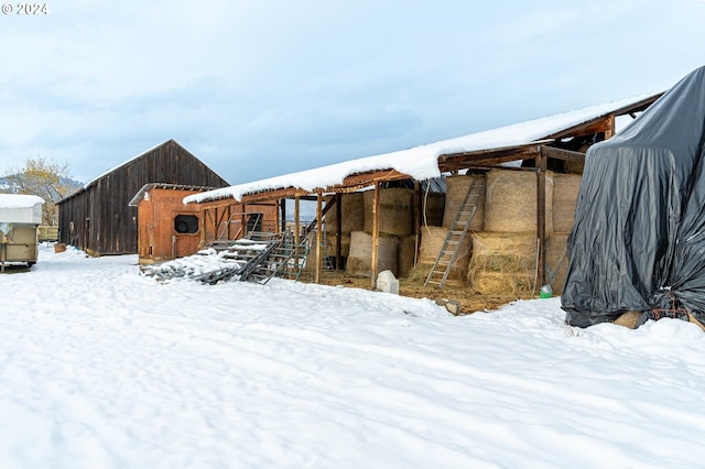 yard layered in snow with an outbuilding