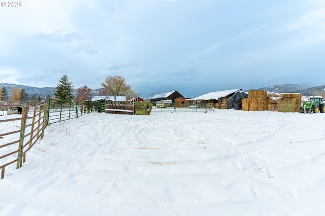 yard covered in snow featuring a mountain view